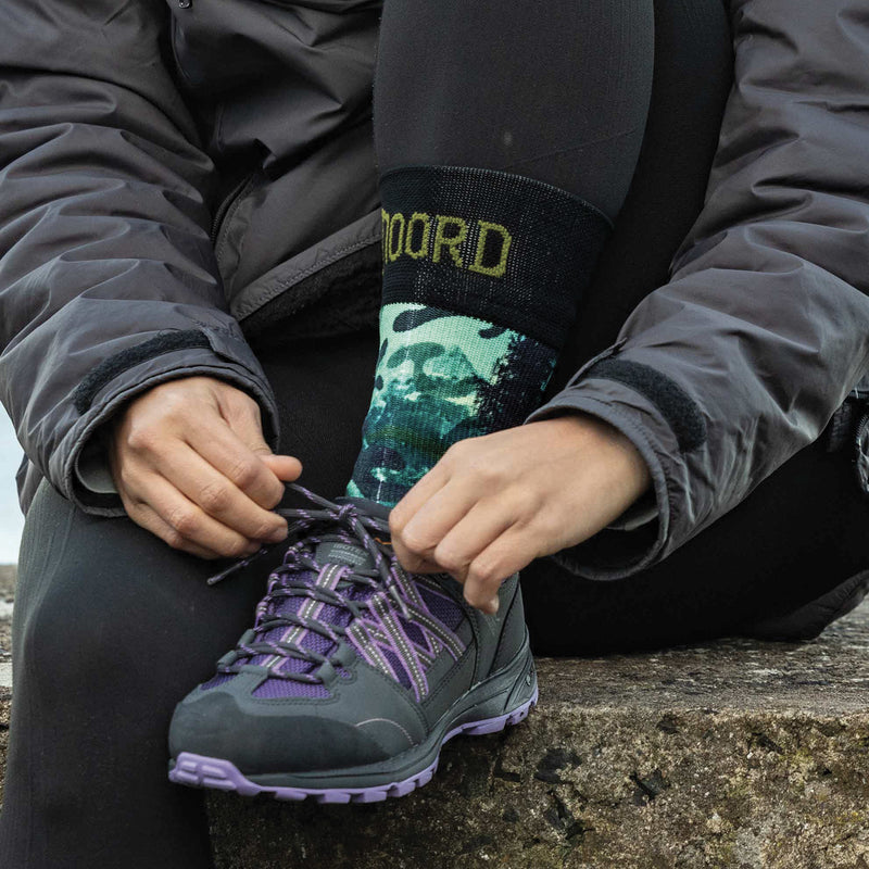 Load image into Gallery viewer, Person tying a purple hiking shoe outdoors whilst wearing noord waterproof socks