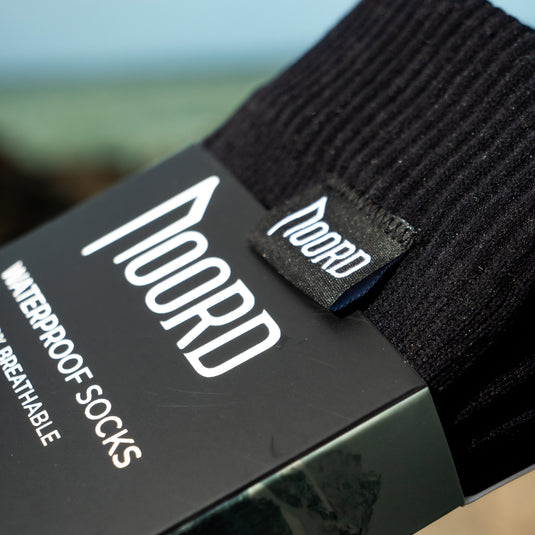 Black waterproof socks with a visible brand label on packaging