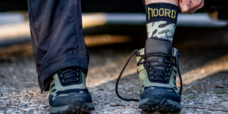 hiking boots and waterproof socks with 'Noord' branding on a blurred natural background for outdoor hiking and trail running