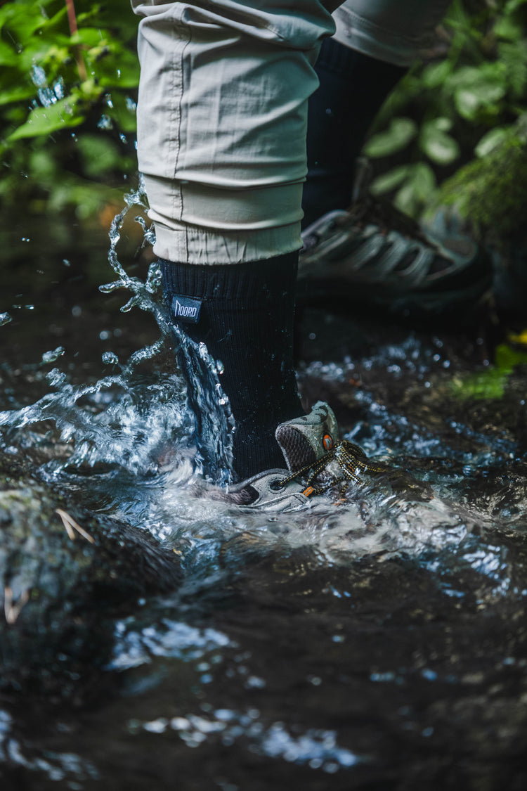 Waterproof socks worn while hiking through a stream in trail hiking shoes.